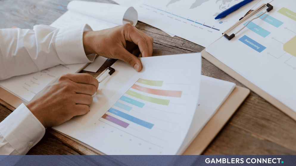 Business documents, charts, and financial graphs examined on a wooden desk representing regulatory market analysis