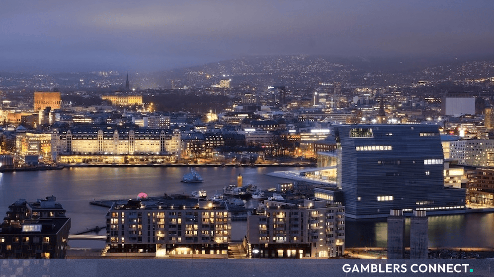 Elevated view of the illuminated city skyline and waterfront in Oslo, Norway at dusk.
