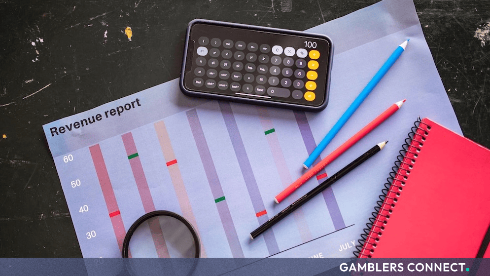 Revenue report charts, calculator, and stationery representing financial results and market analysis for gaming operations.