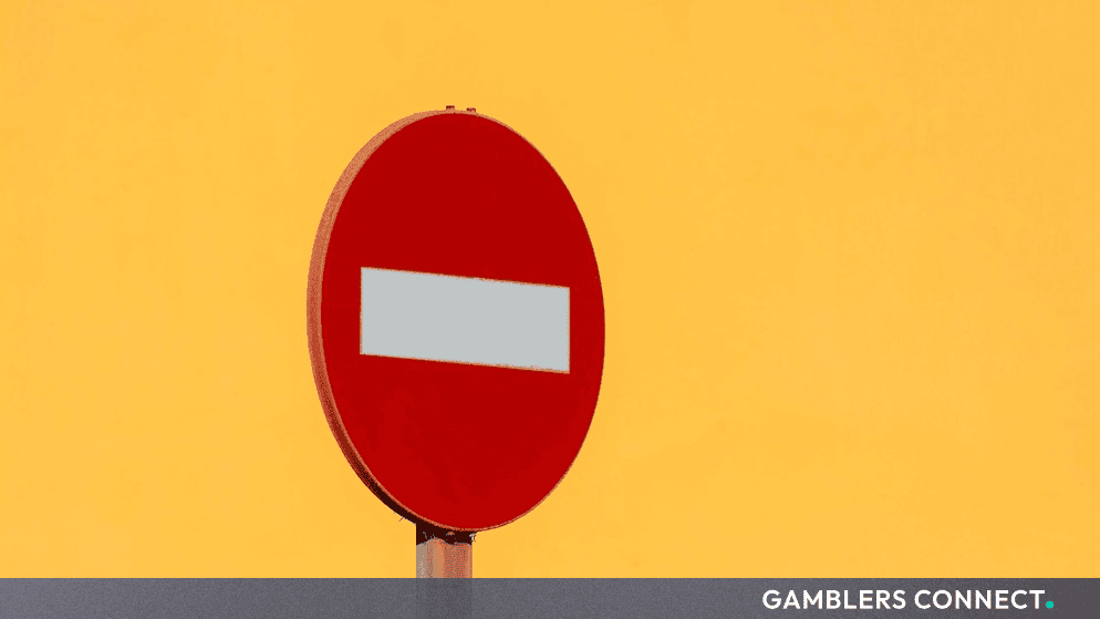Red and white circular traffic stop sign against a solid yellow background representing regulatory prohibition and enforcement